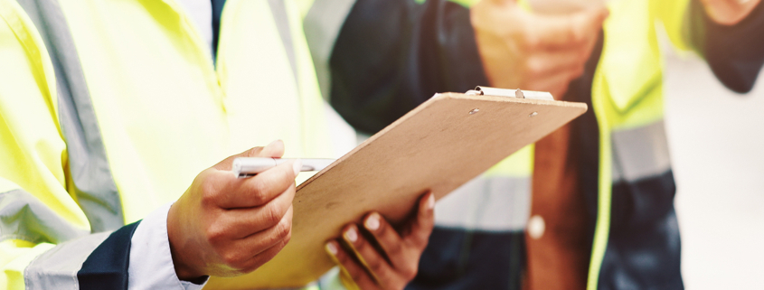 home inspector with clipboard in hand, checking off inspection points
