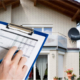 Home inspection document held in front with house in background