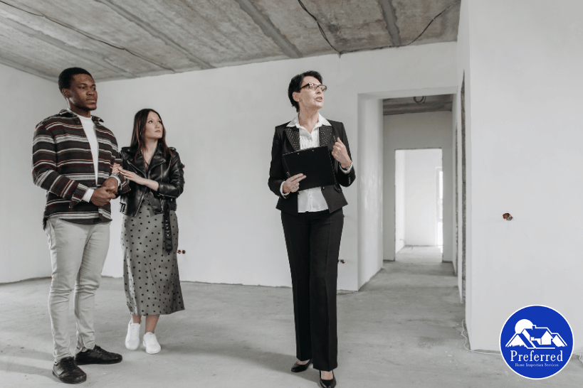Female home inspector with couple reviewing structural systems of new home