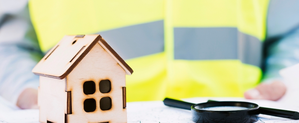 Model house, inspection plans, and magnifying glass symbolizing a professional home inspection in Delaware
